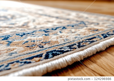 Close up of a fringed edge on a handmade persian rug with intricate design, resting on a polished wooden floor 124296986
