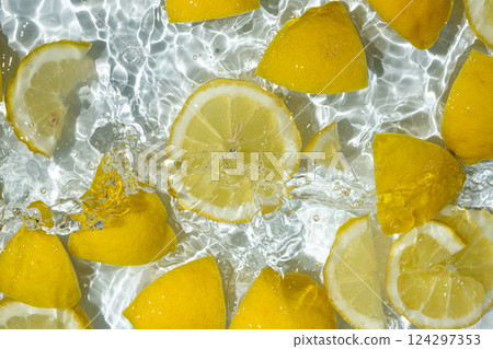 Slices of fresh lemons in water, splash of water, top view. Slices of fresh lemons in water, splash of water, top view. 124297353