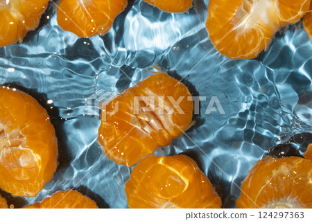 Peeled fresh mandarin halves in water, splash water, top view 124297363