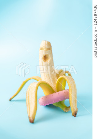 Unique banana with a donut on a blue background creates a playful and colorful display 124297436