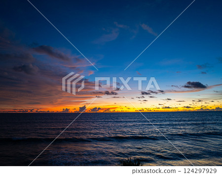 Aerial view of sky turns yellow to orange and red over the sea. Aerial view of sky turns yellow to orange and red over the sea. 124297929