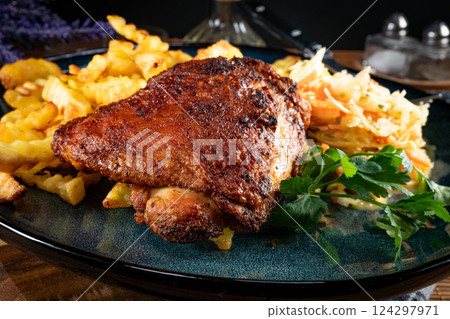 Crispy roasted chicken piece with french fries and salad. 124297971