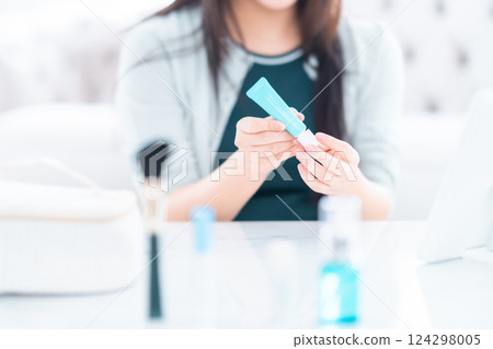 A young woman picking up basic cosmetics, no face 124298005