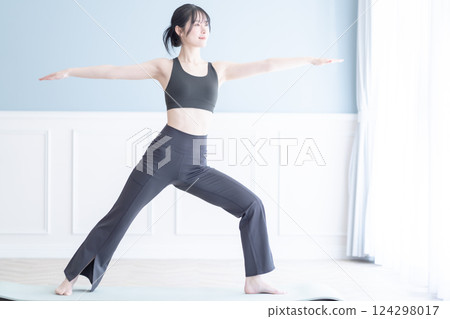 在明亮的工作室裡練習瑜珈的年輕女子 124298017