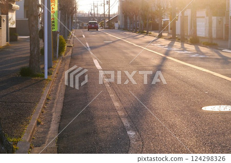 道路被夕陽染紅，路邊的樹影很長，引擎靜靜地轟鳴著 124298326