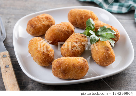 Fried cod croquettes on wooden table 124299904