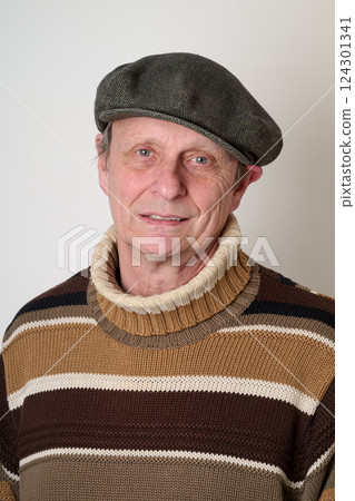 Senior man with a beige turtleneck puulover and a vintage cap 124301341