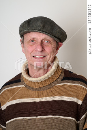 Senior man with a beige turtleneck puulover and a vintage cap Senior man with a beige turtleneck puulover and a vintage cap 124301342