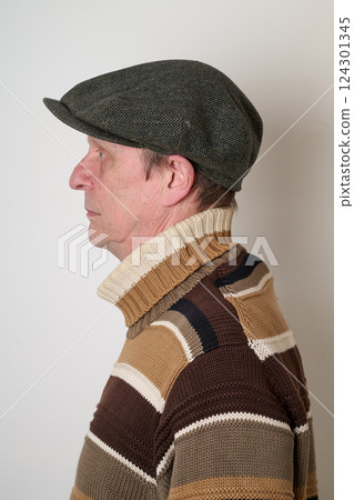 Senior man with a beige turtleneck puulover and a vintage cap 124301345