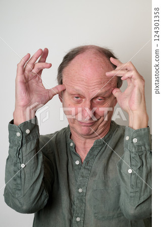 Old man in green shirt make a ugly face in front of camera Old man in green shirt make a ugly face in front of camera 124301358