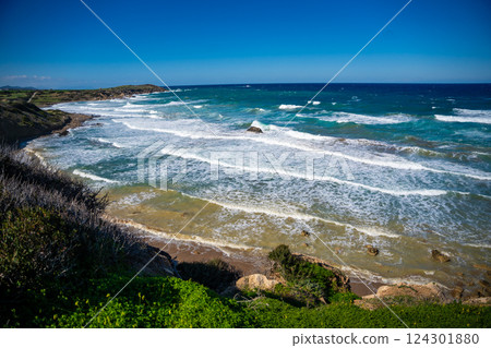 A wild beach with a rugged rocky coastline and powerful waves crashing against the shore in Northern Cyprus. Raw energy of nature and the untamed beauty of the Mediterranean Sea 124301880