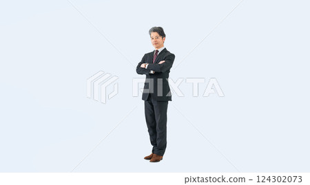 Full-body photo of a middle-aged male business person standing with his arms folded 124302073