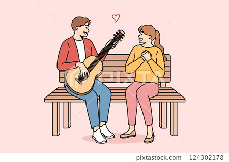 Man sings romantic serenade to woman and plays guitar, sitting on bench during date in park 124302178
