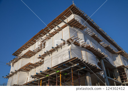 Building Corner Under Construction with Metal Beams and Scaffolding 124302412