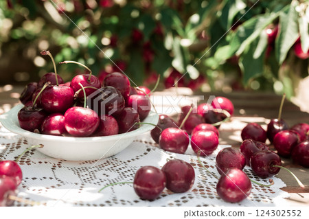White bowl filled with ripe cherries on the table White bowl filled with ripe cherries on the table 124302552