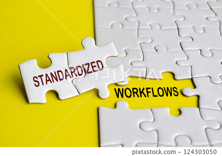 Standardized workflows text on jigsaw puzzle. Process improvement concept Standardized workflows text on jigsaw puzzle. Process improvement concept 124303050