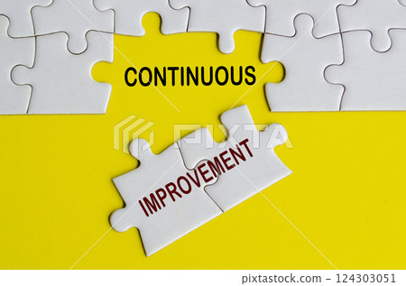 Top view of Continuous Improvement text on jigsaw puzzle. Business strategy and improvement concept. 124303051