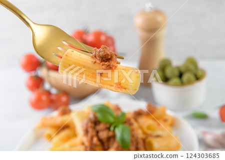 Traditional rigatoni Bolognese on fork close up Traditional rigatoni Bolognese on fork close up 124303685