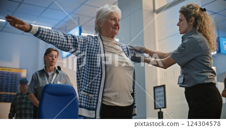 Security Checkpoint: Female TSA Officer Checking Elderly Woman Getting Up from Wheelchair 124304578