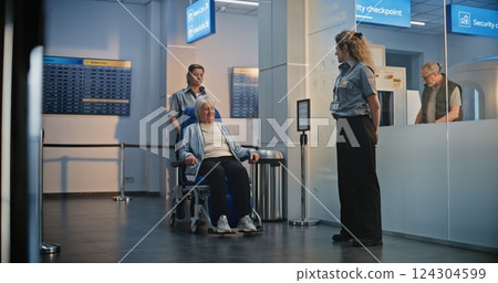 Female TSA Officer Checking Elderly Woman Getting Up from Wheelchair in Airport Terminal Female TSA Officer Checking Elderly Woman Getting Up from Wheelchair in Airport Terminal 124304599