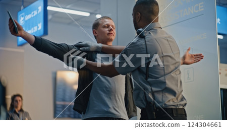 Security Checkpoint in Airport Terminal: Security Officer Inspecting Young Man with Prosthesis Leg 124304661