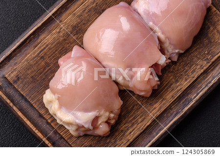 Fresh raw chicken thigh fillets with salt, spices and herbs 124305869