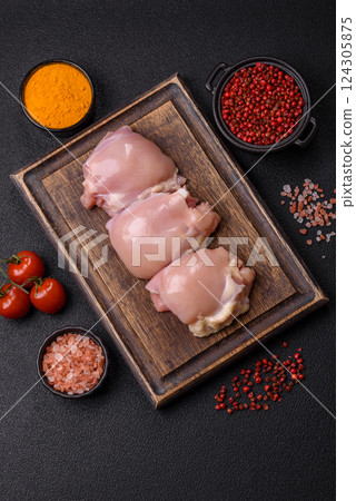 Fresh raw chicken thigh fillets with salt, spices and herbs 124305875
