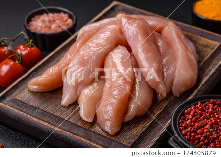 Raw chicken fillet cut into strips with spices and herbs Raw chicken fillet cut into strips with spices and herbs 124305879
