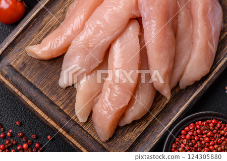 Raw chicken fillet cut into strips with spices and herbs 124305880