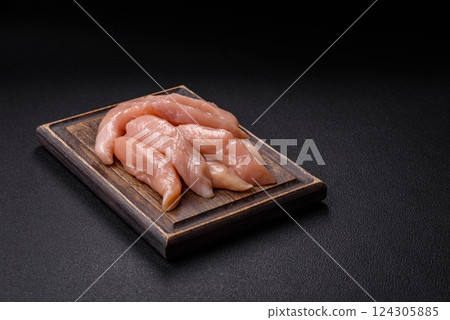 Raw chicken fillet cut into strips with spices and herbs 124305885