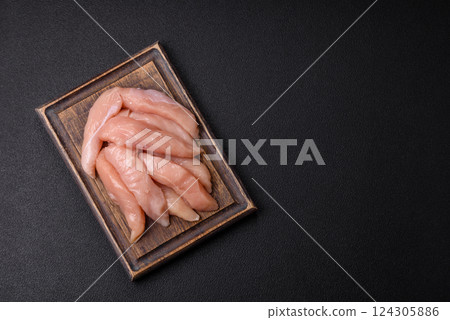Raw chicken fillet cut into strips with spices and herbs 124305886