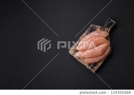 Raw chicken fillet cut into strips with spices and herbs 124305889