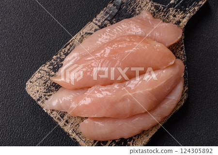 Raw chicken fillet cut into strips with spices and herbs 124305892