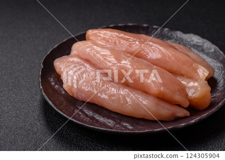Raw chicken fillet cut into strips with spices and herbs 124305904
