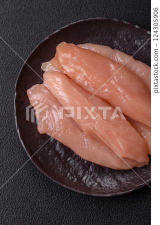 Raw chicken fillet cut into strips with spices and herbs Raw chicken fillet cut into strips with spices and herbs 124305906