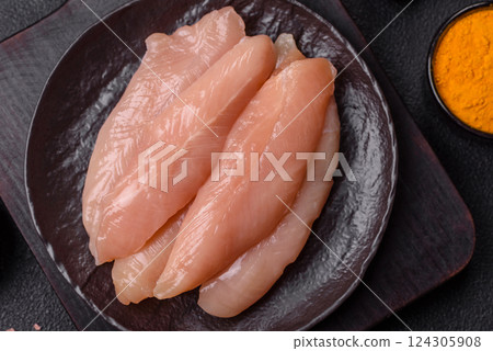 Raw chicken fillet cut into strips with spices and herbs 124305908