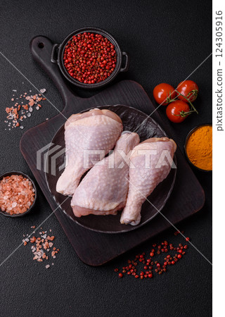 Raw chicken legs with salt, spices and herbs 124305916