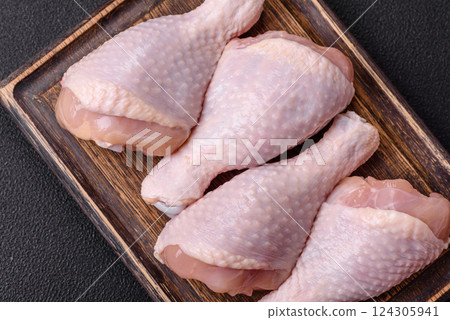 Raw chicken legs with salt, spices and herbs 124305941