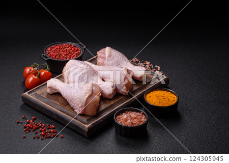 Raw chicken legs with salt, spices and herbs 124305945