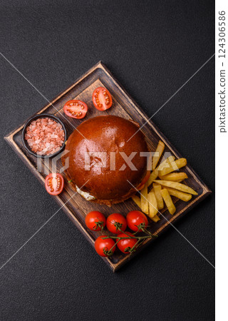 Delicious burger with beef patty, fried egg, bacon, herbs, sauce, salt and spices 124306586