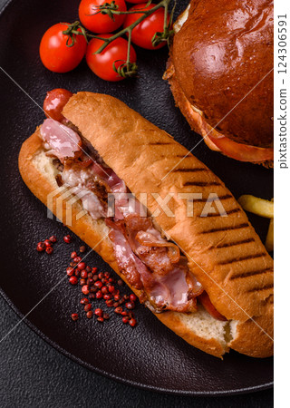 Delicious juicy hot dog with sausage, bacon, sauce, salt and spices Delicious juicy hot dog with sausage, bacon, sauce, salt and spices 124306591