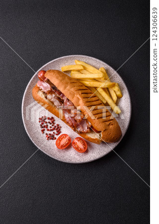 Delicious juicy hot dog with sausage, bacon, sauce, salt and spices Delicious juicy hot dog with sausage, bacon, sauce, salt and spices 124306639