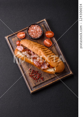 Delicious juicy hot dog with sausage, bacon, sauce, salt and spices 124306654