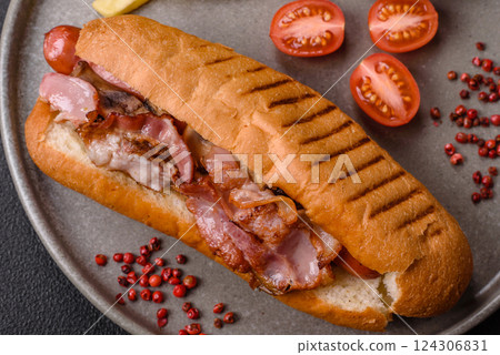 Delicious juicy hot dog with sausage, bacon, sauce, salt and spices Delicious juicy hot dog with sausage, bacon, sauce, salt and spices 124306831