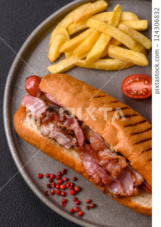 Delicious juicy hot dog with sausage, bacon, sauce, salt and spices Delicious juicy hot dog with sausage, bacon, sauce, salt and spices 124306832