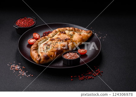 Cheburek meat pastry pie with herbs on the concrete background Cheburek meat pastry pie with herbs on the concrete background 124306978
