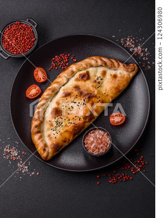 Cheburek meat pastry pie with herbs on the concrete background Cheburek meat pastry pie with herbs on the concrete background 124306980