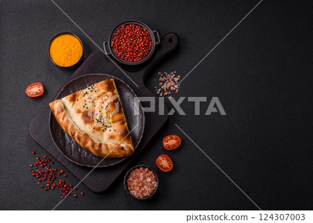 Cheburek meat pastry pie with herbs on the concrete background 124307003