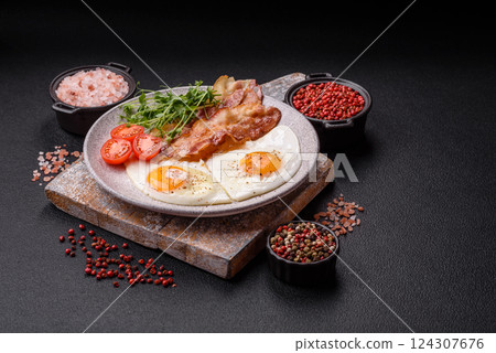 A hearty breakfast with fried eggs, bacon, tomatoes, microgreens A hearty breakfast with fried eggs, bacon, tomatoes, microgreens 124307676