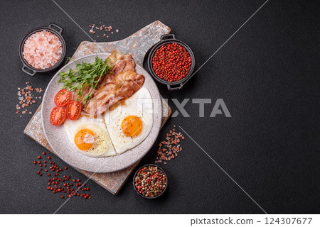 A hearty breakfast with fried eggs, bacon, tomatoes, microgreens 124307677